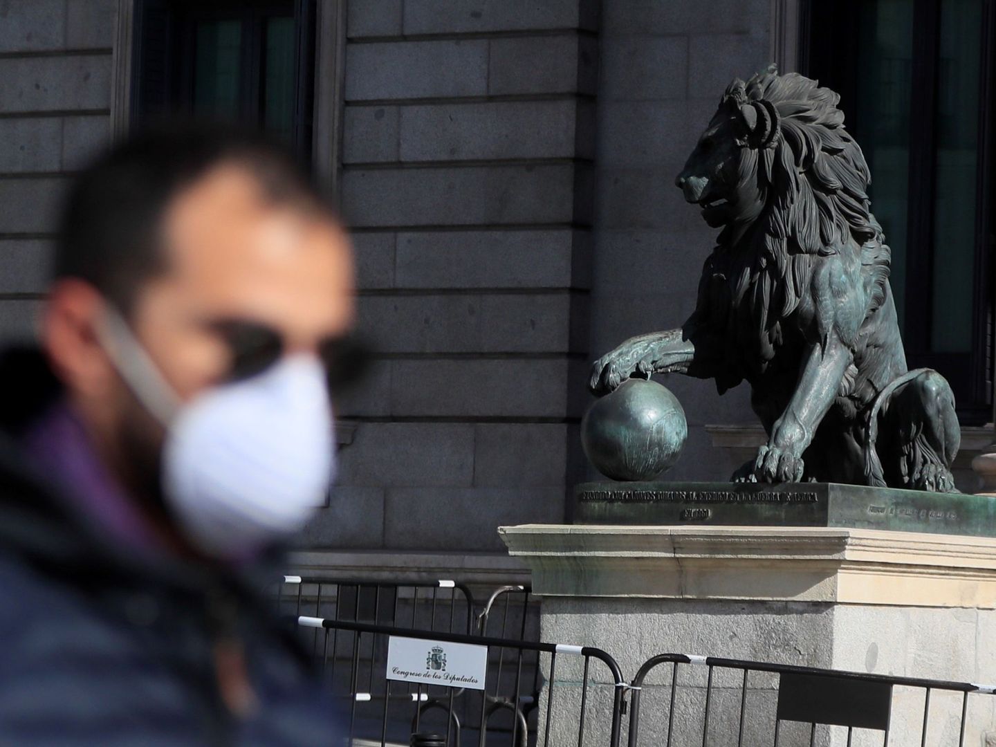Un hombre con mascarilla pasea frente al Congreso de los Diputados en Madrid, este viernes. (EFE)