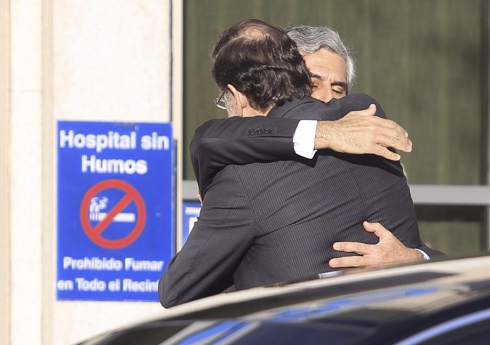 Foto: Suárez Illana abraza a Mariano Rajoy a las puertas de la clínica. (Efe)