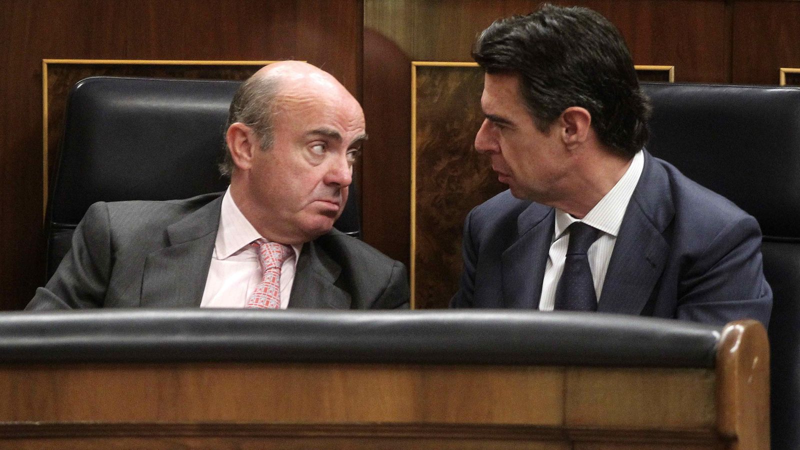 Foto: El ministro de Economía, Luis de Guindos, y el extitular de Industria, José Manuel Soria, conversan en el Congreso en un pleno de 2015. (EFE)