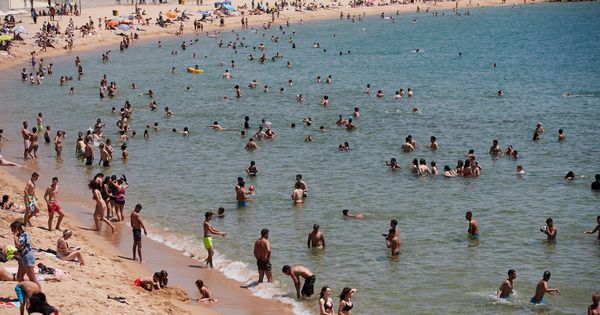 Foto: Unos bañitas en una playa de Barcelona. (EFE)