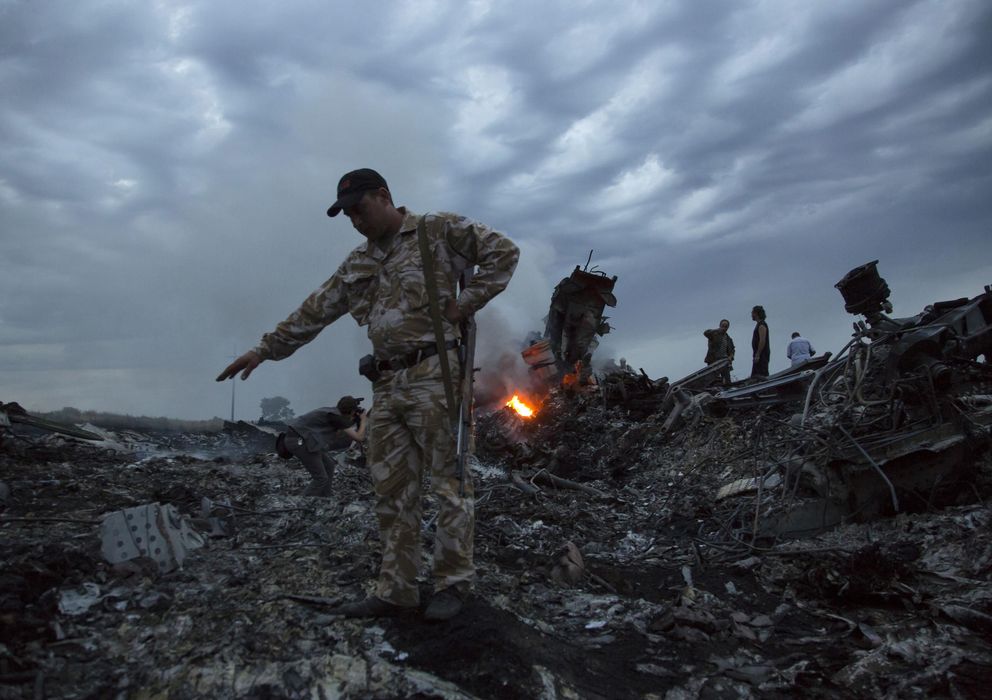 Foto: Un grupo de personas camina entre los restos del avión derribado en el Este de Ucrania (AP).