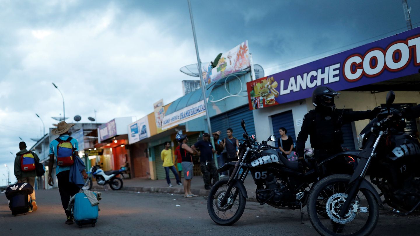 Policías y inmigrantes venezolanos en el control de fronteras en Paracaima (Brasil).  (Reuters)