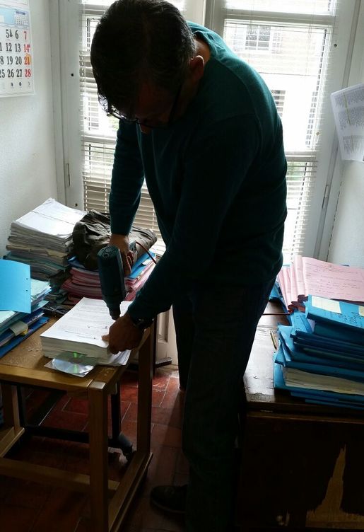 Un funcionario utiliza un taladro para encuadernar tomos en un juzgado de Madrid. (EC)