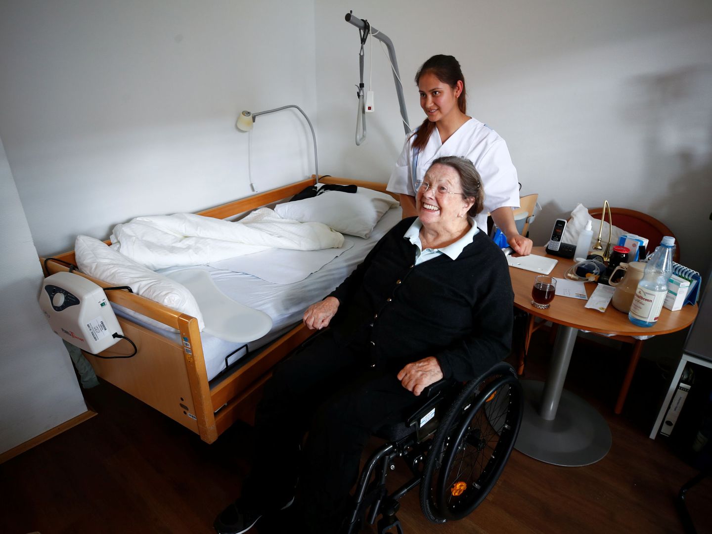 La anciana Elisabeth Grohmann es ayudada por la refugiada afgana Elahi Temori en Düsseldorf, en septiembre de 2018. (Reuters)