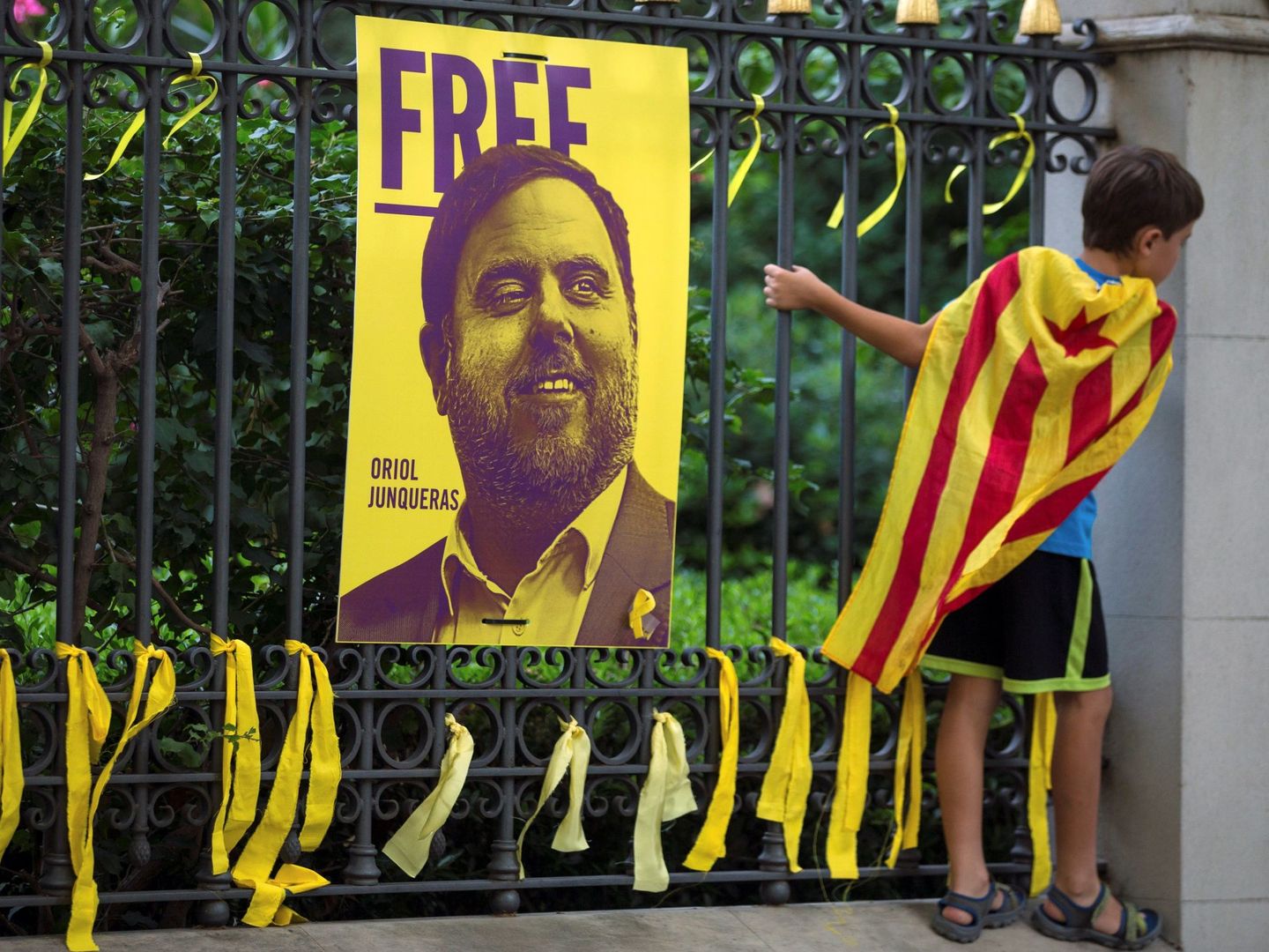 Lazos amarillos colocados ante una fotografía del exvicepresidente Oriol Junqueras, durante la Diada de 2018. (EFE)