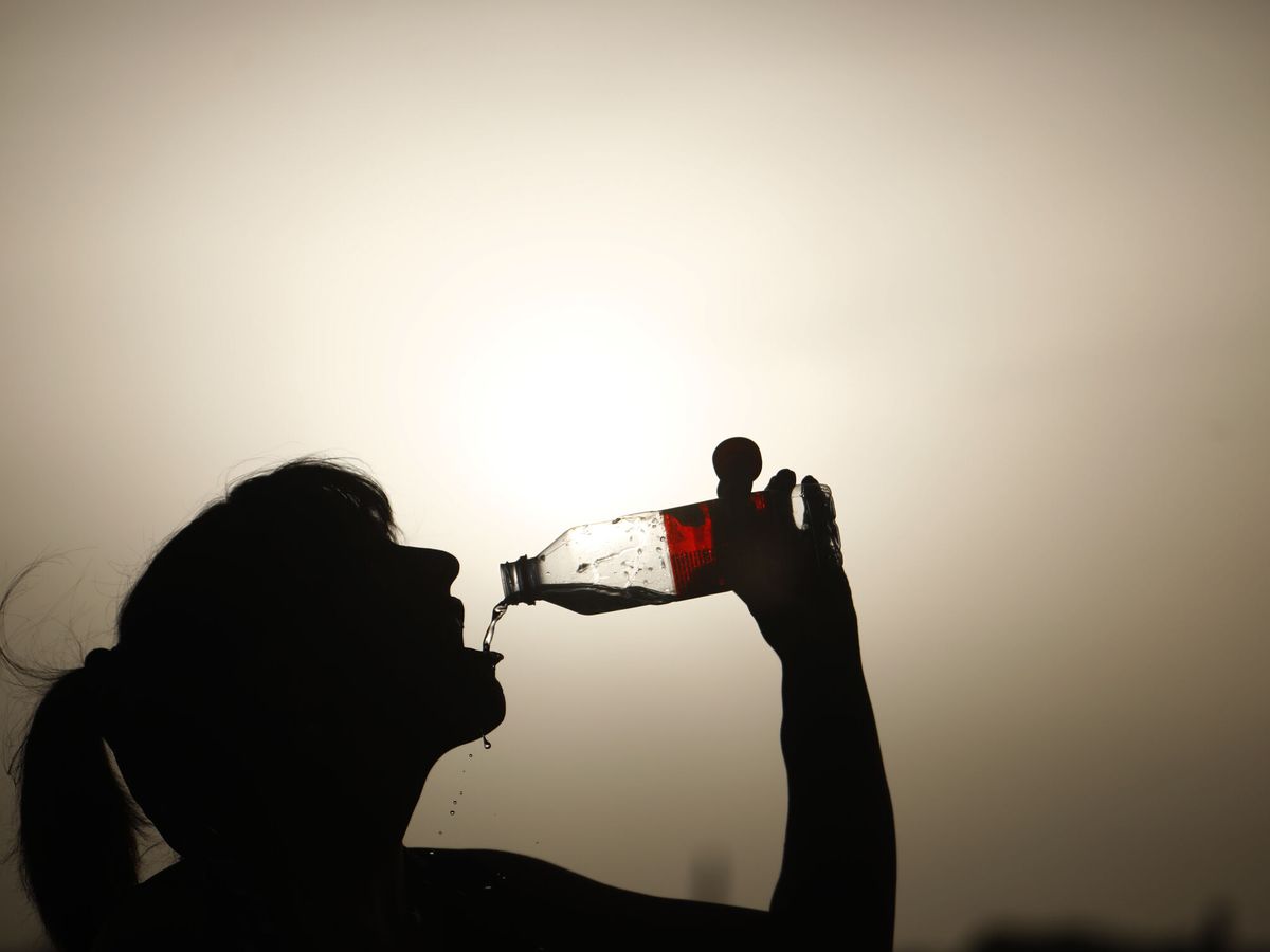 Foto: Una turista bebe agua en Córdoba para aliviar el calor el 13 de agosto. (EFE/Salas)