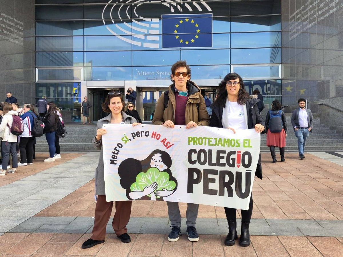 Foto: Tres familiares de escolares matriculados en el colegio Perú de Madrid, este martes frente al Parlamento Europeo. (Cedida)
