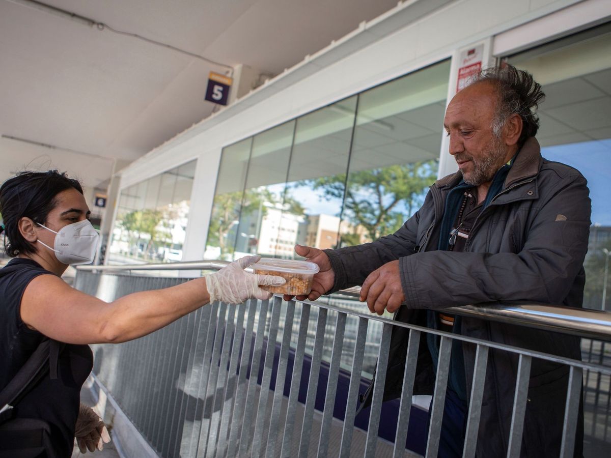 Foto: Un indigente recibe la ayuda de una voluntaria de la Fundació Arrels. Foto: EFE Enric Fontcuberta.