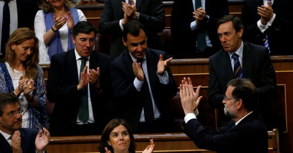Foto: El presidente del Gobierno, Mariano Rajoy (d, abajo), aplaude con la bancada popular tras la votación. (Reuters)