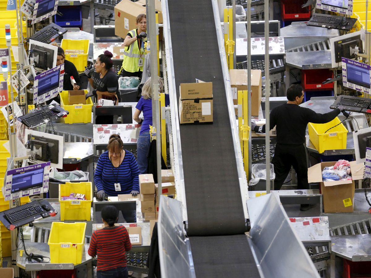 Foto: Trabajadores en una cadena de producción de Amazon. (Reuters)