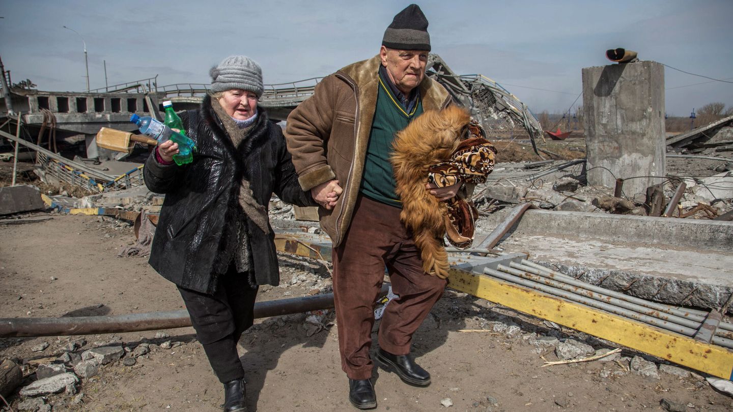 Una pareja de ancianos camina junto a un puente destruido durante la evacuación de la ciudad de Irpin este 28 de marzo. (Reuters/Oleksandr Ratushniak)