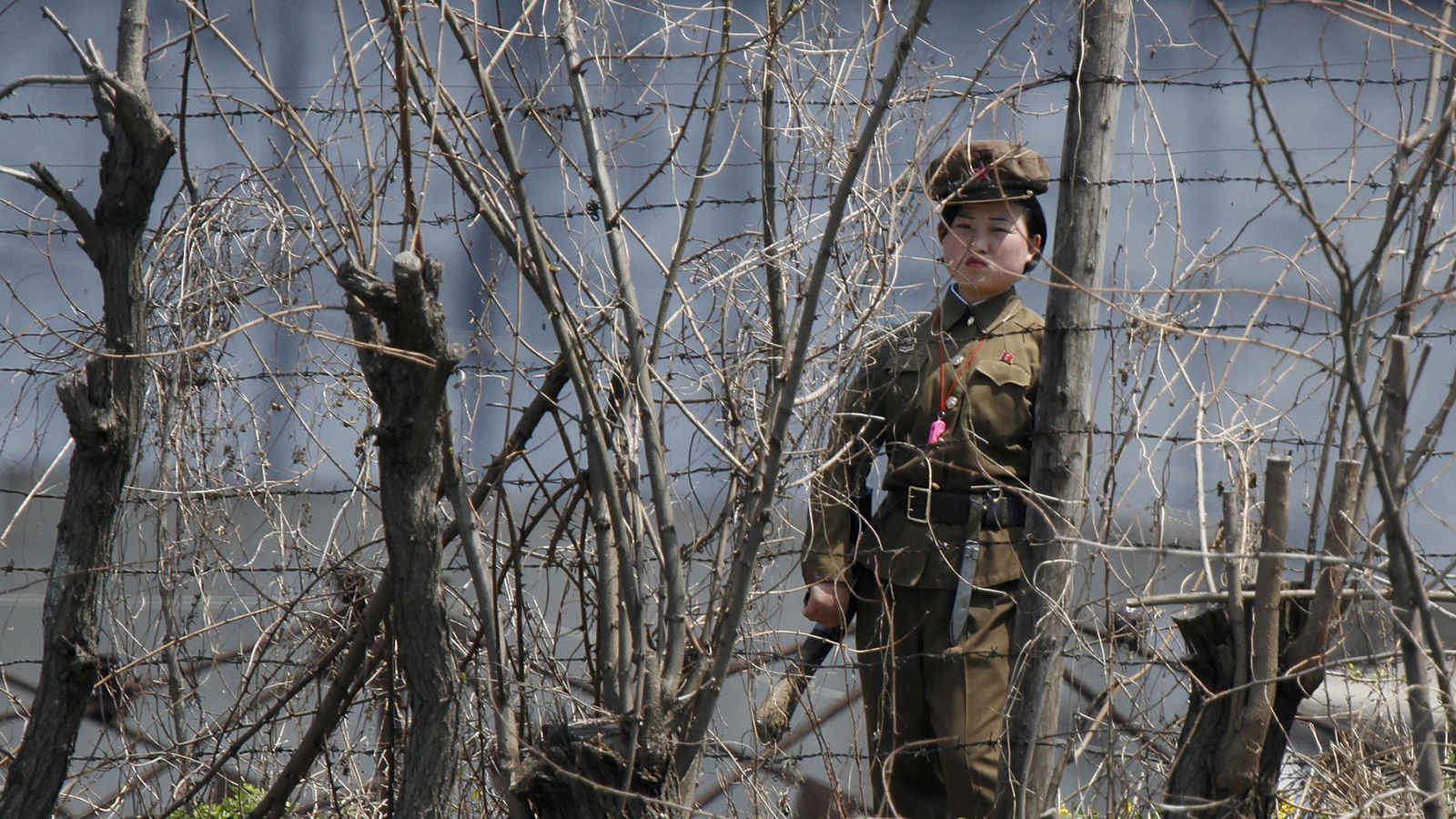 Foto: Una guardiana de prisiones norcoreana custodia la verja de una cárcel junto al río Yalu, en la frontera con China, en mayo de 2011. (Reuters)