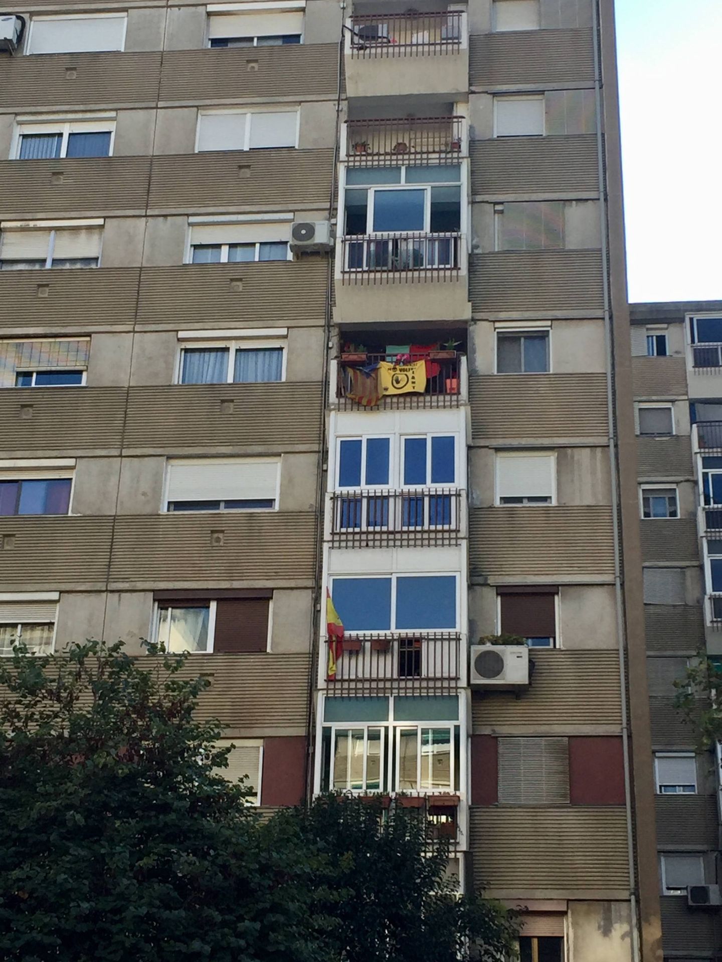 Una estelada y una bandera de España colgadas de los balcones de un bloque de viviendas en la avenida de Burgos de Badia, este 29 de septiembre. (J. R.)