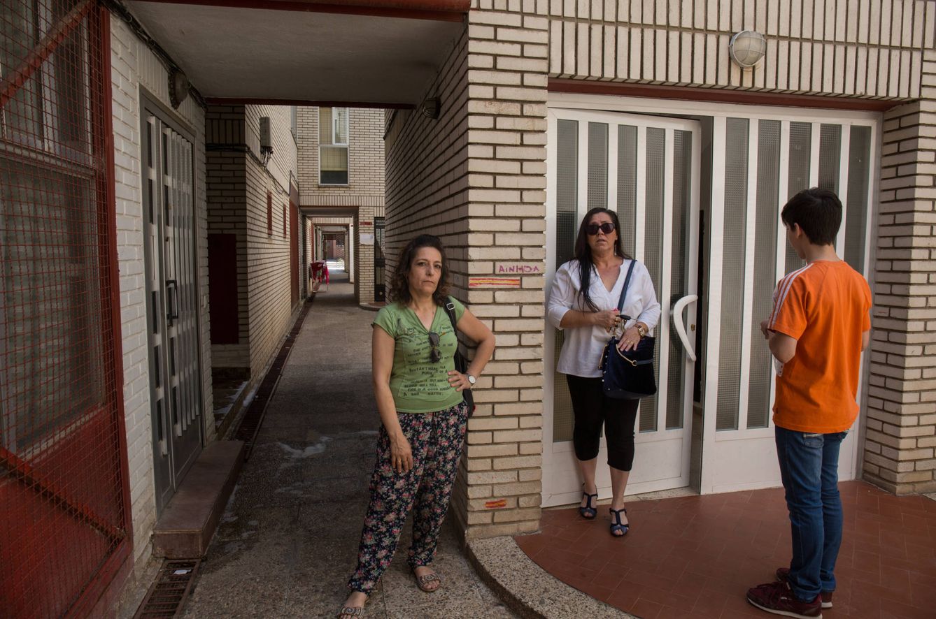Montse Lozano (centro) junto a su amiga Teresa y uno de sus hijos en el portal de su vivienda.