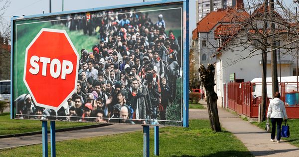 Foto: Una mujer pasa frente a un mural antiinmigración colocado por el partido gubernamental Fidesz, en Gyongyos, en abril de 2018. (Reuters)