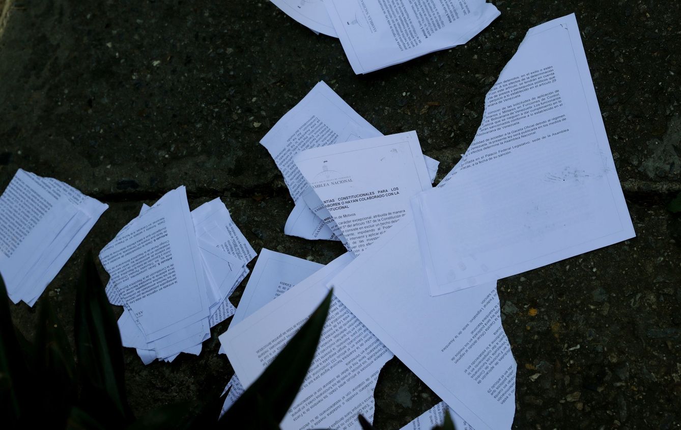 Personal de La Casona destroza los documentos con la Ley de Amnistía de Guaidó. (EFE)