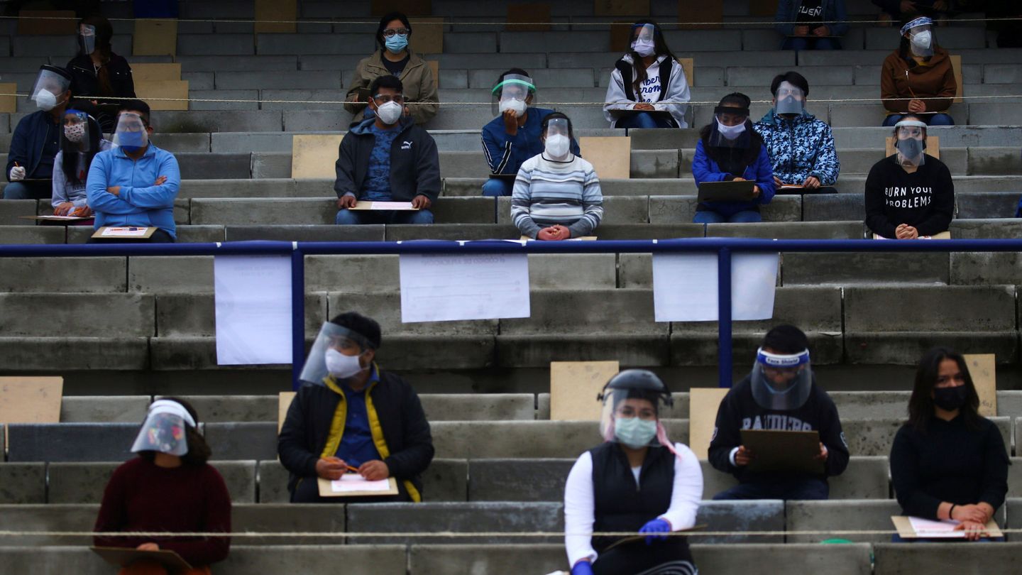 Varios jóvenes, con mascarillas y pantallas protectoras durante su examen de acceso a la Universidad Nacional Autónoma de México (UNAM), en Ciudad de México (Reuters)