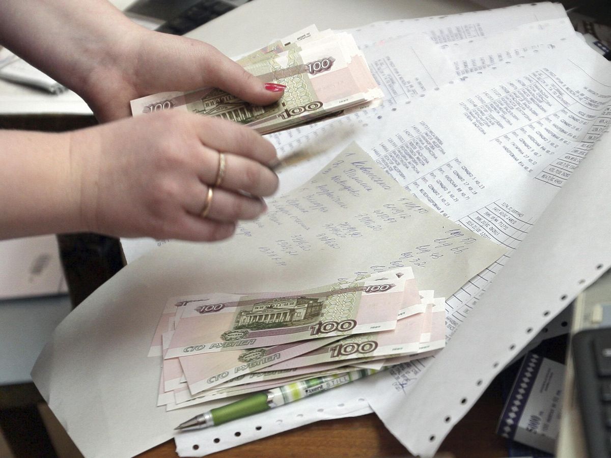 Foto: Una mujer cuenta rublos rusos en una oficina postal de Simferópol. (EFE/Artur Shvarts)