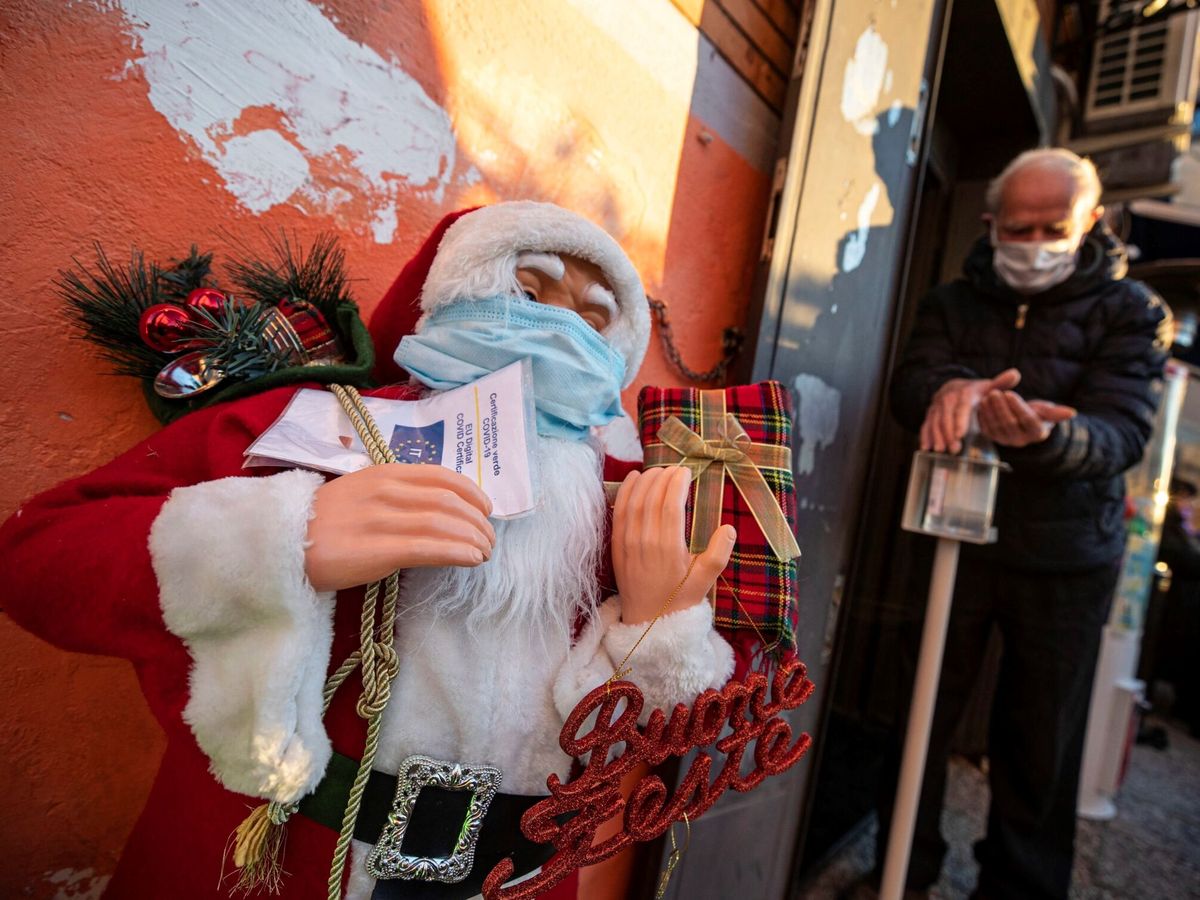 Foto: Un Papá Noel con mascarilla franquea la puerta de un bar. (Reuters)