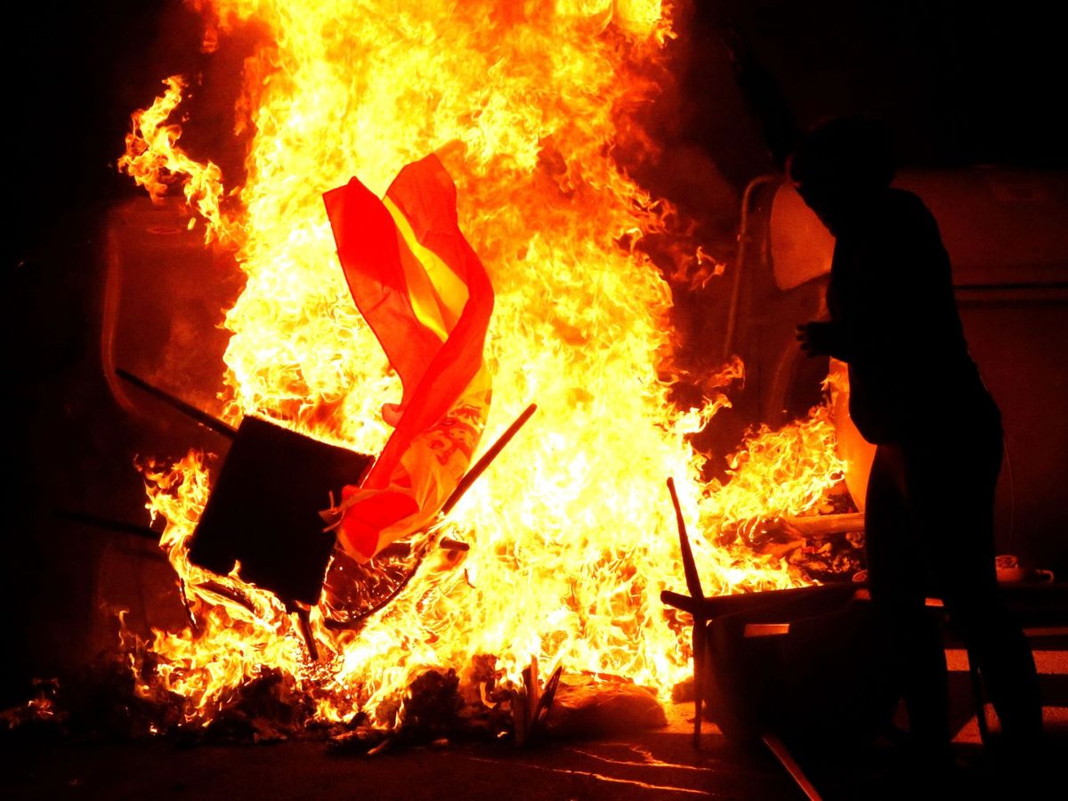 Foto: Un grupo de CDR quema una bandera de España. (EFE)