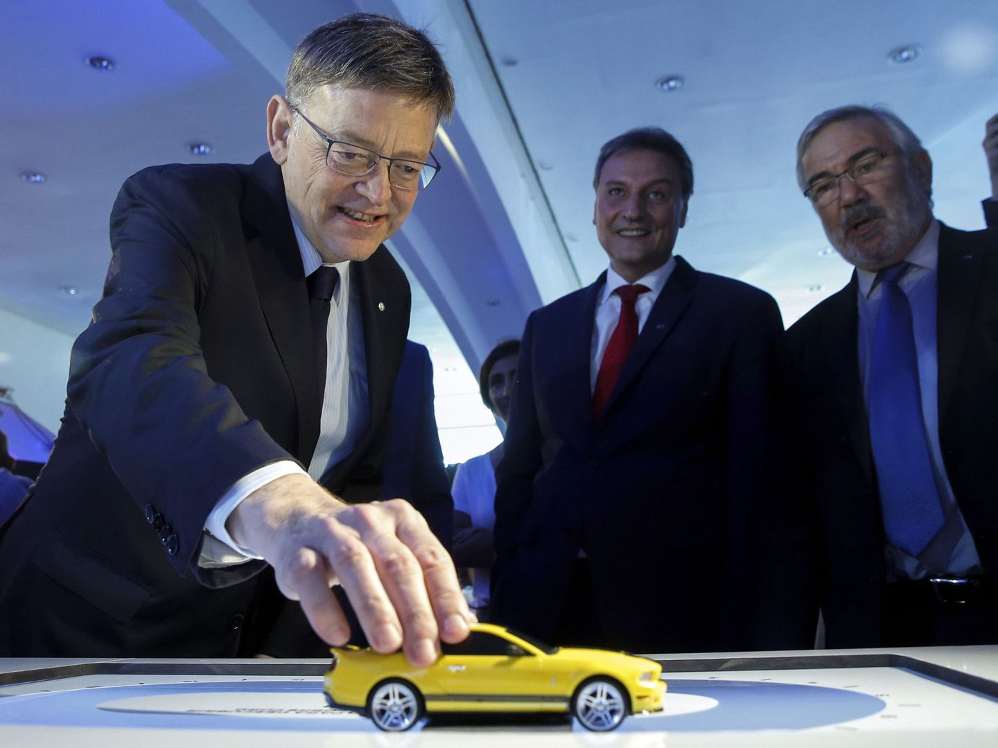 El 'president' de la Generalitat, Ximo Puig (i), maneja un coche a escala en presencia del presidente y consejero delegado de Ford España. (EFE)