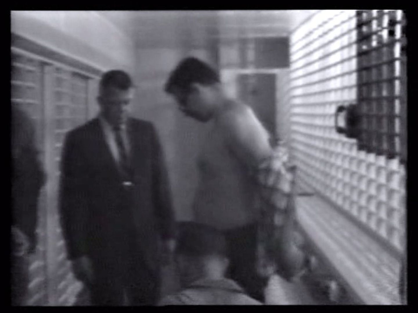 Captura de pantalla de un vídeo fechado el 19 de julio de 1968 que muestra a James Earl Ray (d) mientras es cacheado y procesado, al llegar a la Cárcel del Condado de Shelby, en Memphis. (EFE)