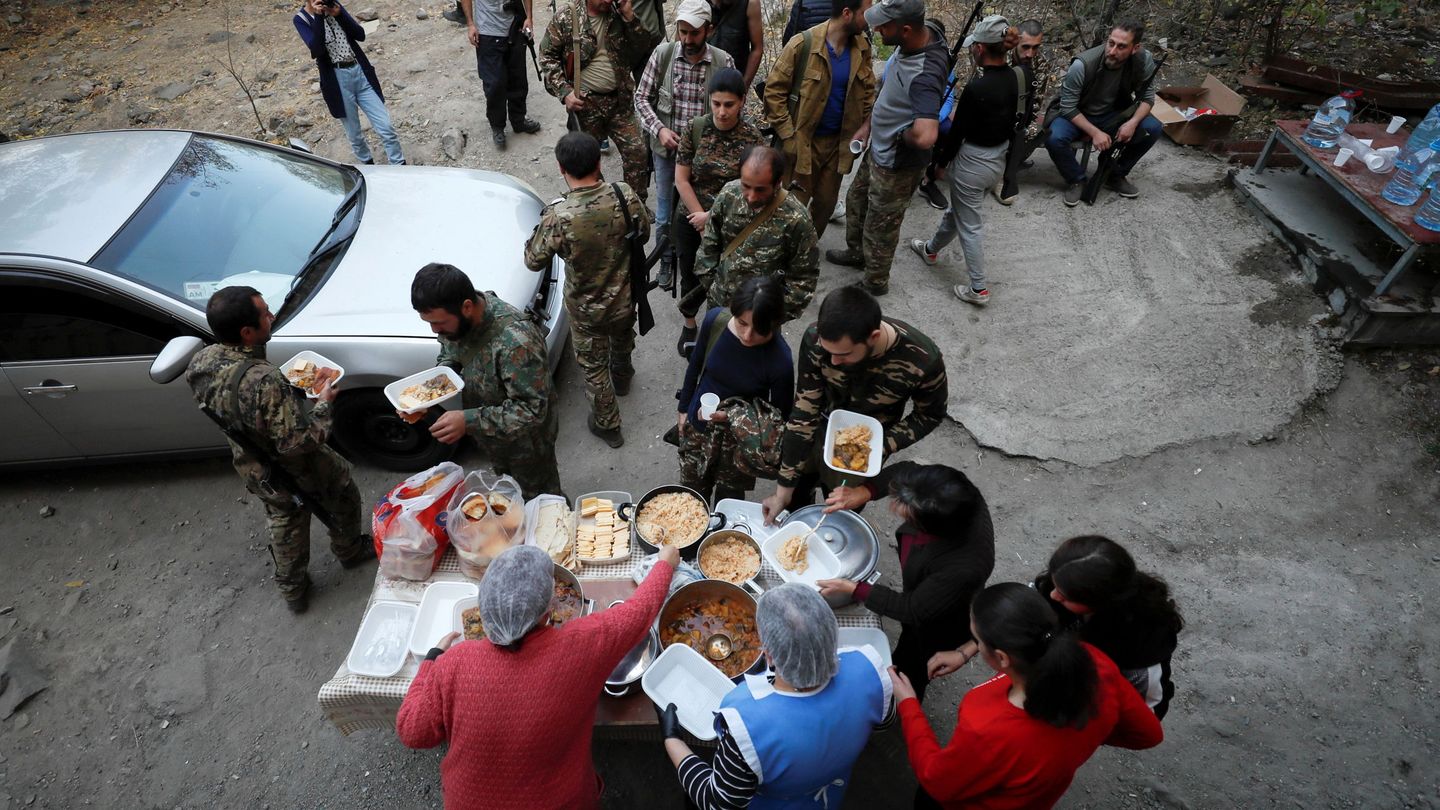 Unas mujeres reparten comida a voluntarios armenios que se han alistado en el frente. (Reuters)