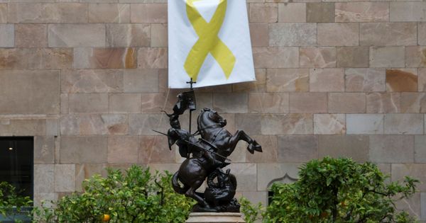 Foto: Una pancarta con un lazo amarillo cuelga de una de las paredes del Pati dels Tarongers. (EFE)