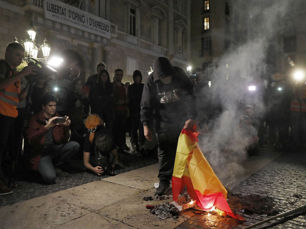 Foto: Un encapuchado quema una bandera española en una imagen de archivo. (EFE)