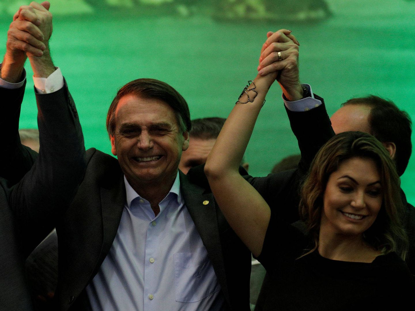 Bolsonaro levanta el brazo de la victoria junto a su esposa. (EFE)