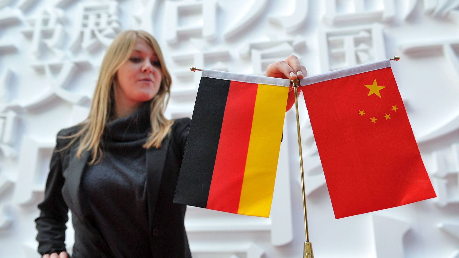 Foto: Una empleada coloca banderas de China y Alemania en uno de los pabellones de la Feria del Libro de Fráncfort. (EFE)