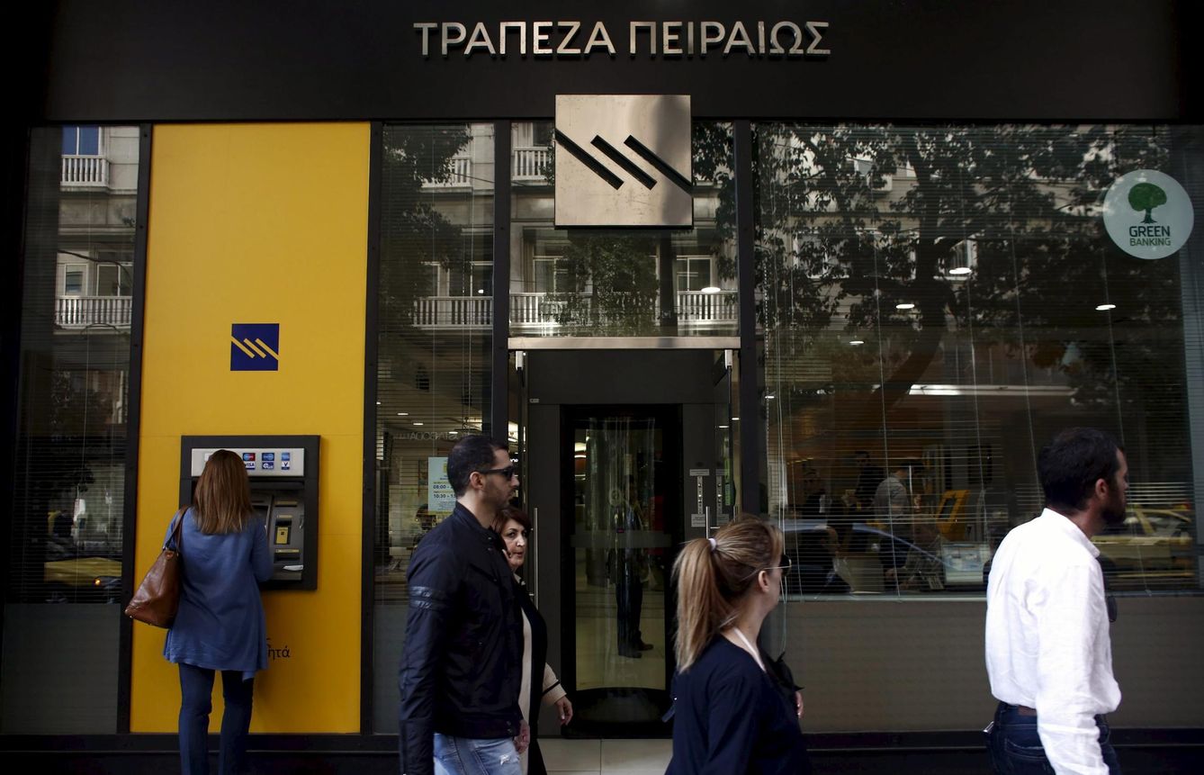 Griegos pasan ante una sucursal del Banco Piraeus en Atenas (Reuters).