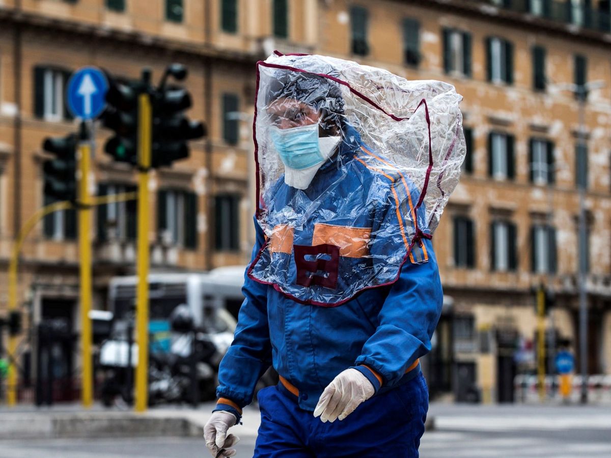 Foto: Un hombre con una bolsa de plástico en la cabeza camina por una calle de Roma. (EFE)