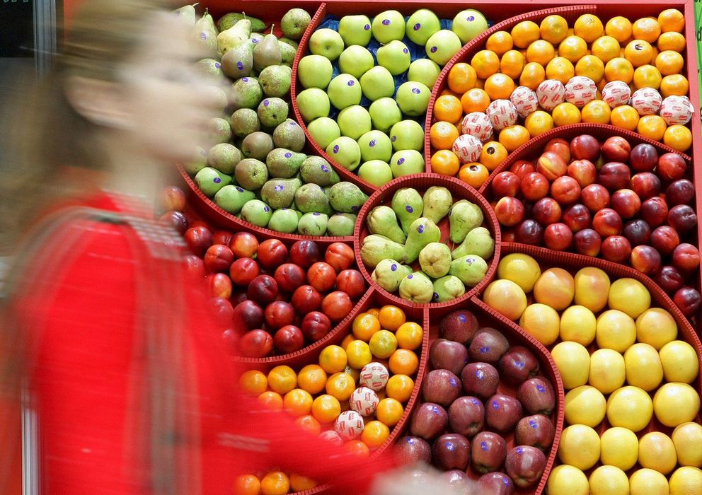Foto: Una mujer pasa al lado de un expositor con frutas procedentes de España. (EFE)