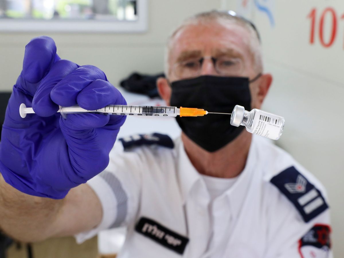 Foto: Un trabajador sanitario israelí enseña un vial de vacunación en Tel Aviv. (Reuters/Ammar Awad)
