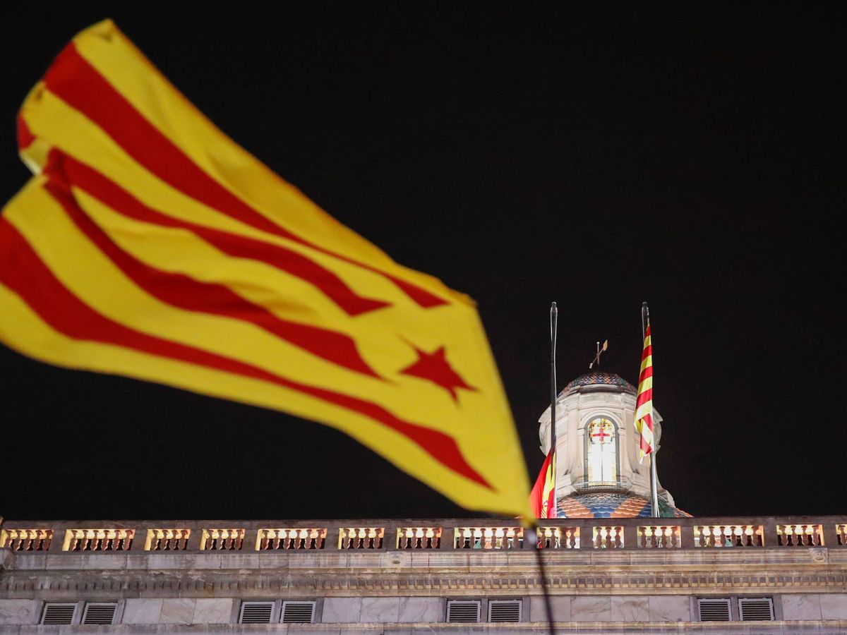 Foto: Una estelada ondea mientras se retira la bandera de España del Palau de la Generalitat. (Reuters)