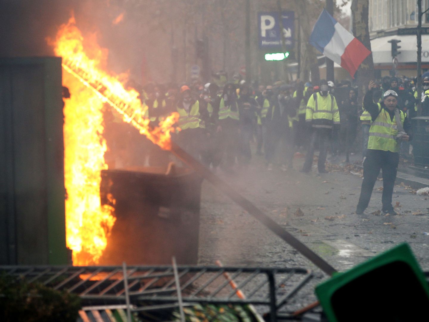 Manifestantes gritan a los antidisturbios frente a una barricada en llamas en la Place de L'Étoile en París. (Reuters)