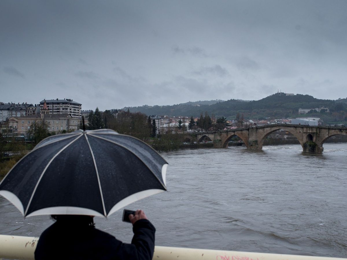 Foto: Un hombre fotografía el caudal del río Miño a su paso por Ourense. (EFE)