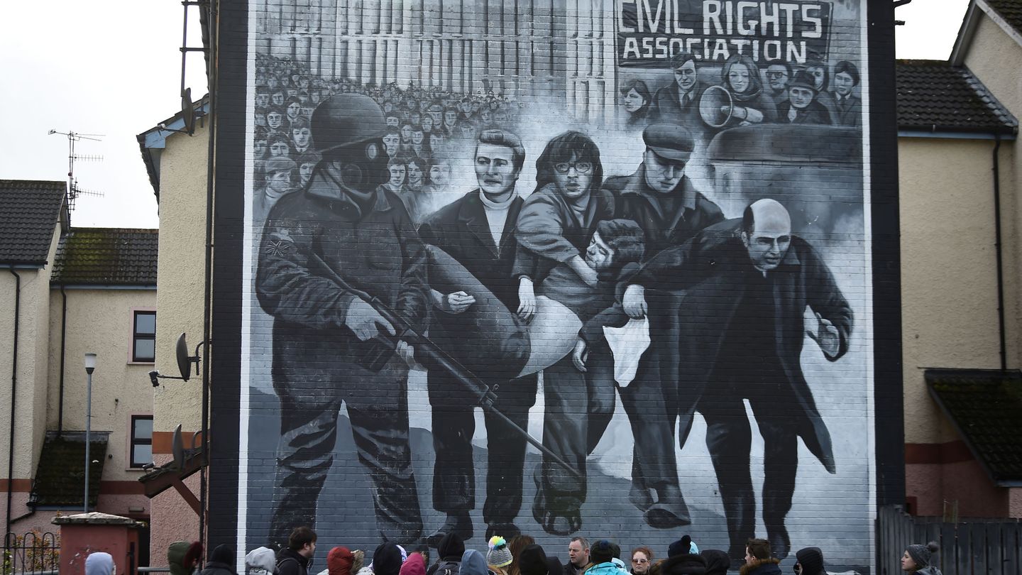 Touristas frente al mural conmemorando el Domingo Sangriento en Irlanda del Norte. (Reuters)
