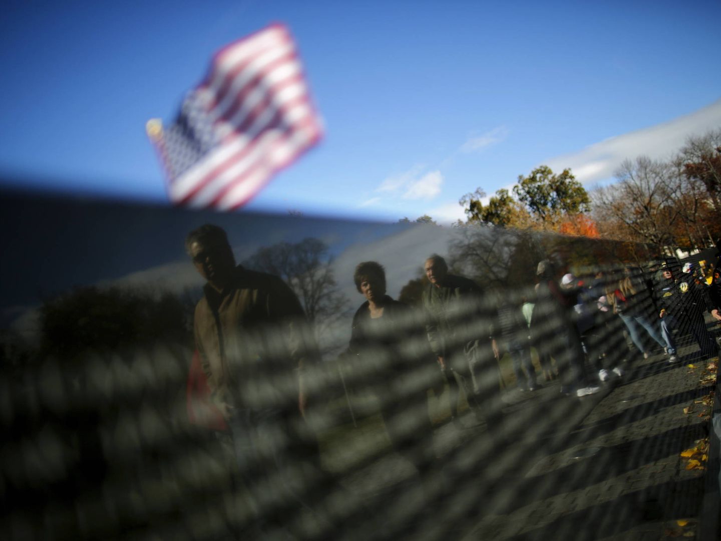 Estadounidenses visitan el monumento en memoria de los veteranos de Vietnam, en Washington, el Día de los Veteranos (Reuters). 