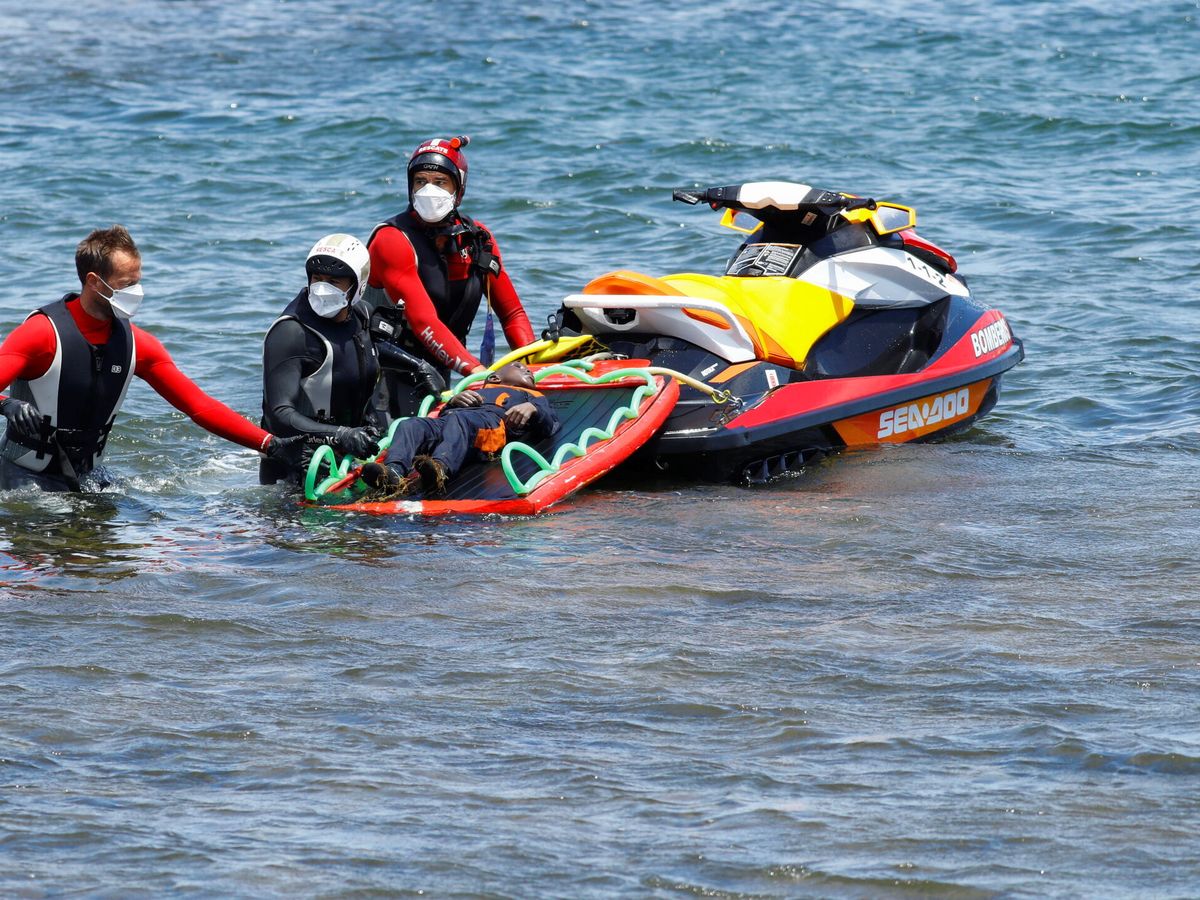 Foto: Trabajadores de rescate remolcan el cuerpo de una víctima de un naufragio en Lanzarote, Canarias. (Reuters/Borja Suárez)