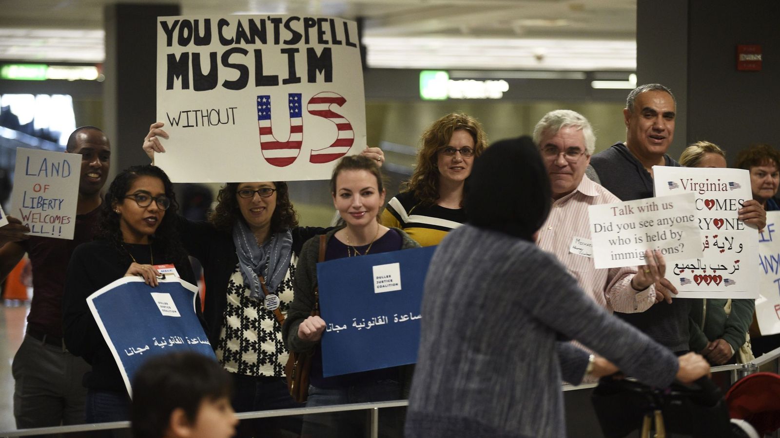 Foto: Viajeros internacionales reciben la bienvenida de un grupo de manifestantes en el Aeropuerto Internacional de Dulles en Sterling, Virginia. (EFE)
