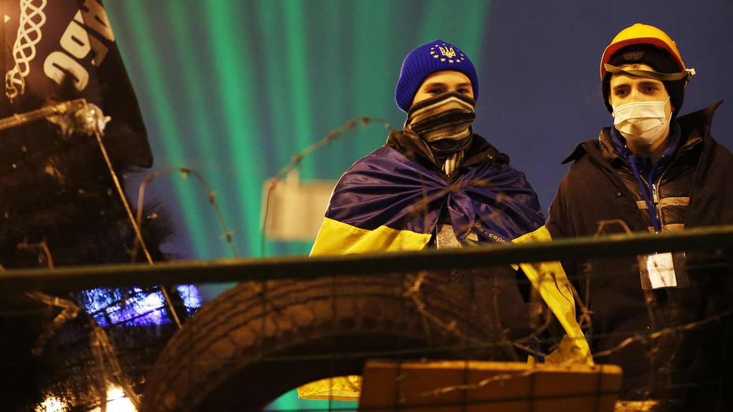 Dos manifestantes pro-europeos en una barricada en el centro de Kiev (Reuters).