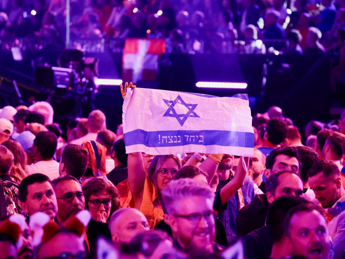 Foto: Una persona sujeta una bandera israelí en la final de Eurovisión. (Reuters/Leonhard Foeger)