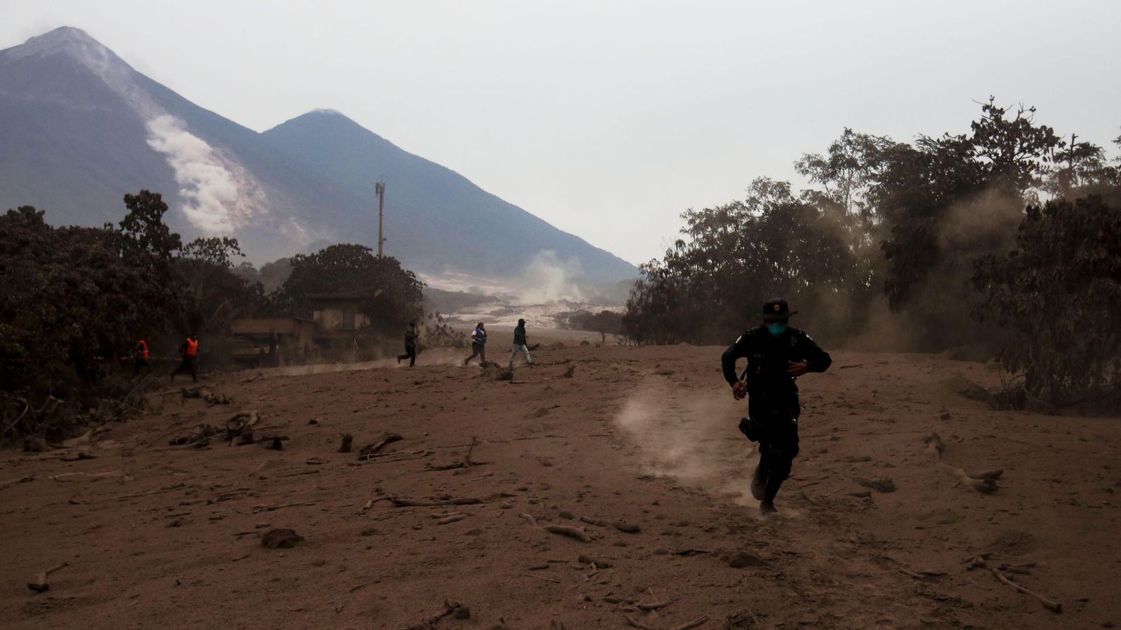 Foto: Un policía corre por un deslizamiento de fluido del volcán de Fuego | EFE Esteban Biba