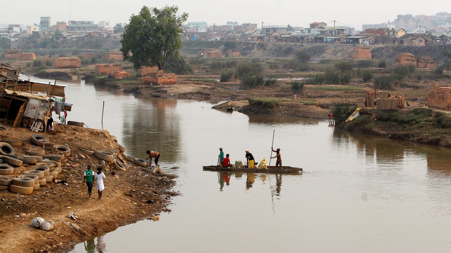 Hombres cruzan el río Ikopa en Antananarivo (Thomas Mukoya / Reuters) 