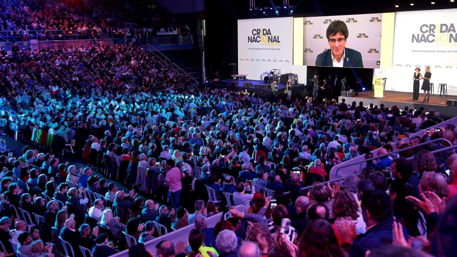 Foto: La Crida celebra su convención fundacional. Al fondo, Puigdemont durante su intervención por video. (EFE)
