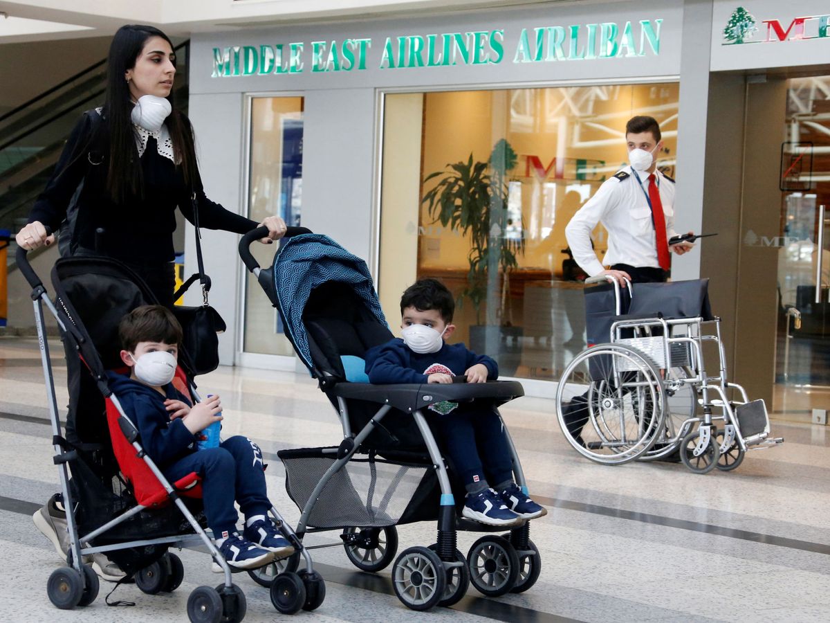 Foto: Children wear facemasks as they sit in a baby cart as a precaution against the spread of the coronavirus, at beirut international airport