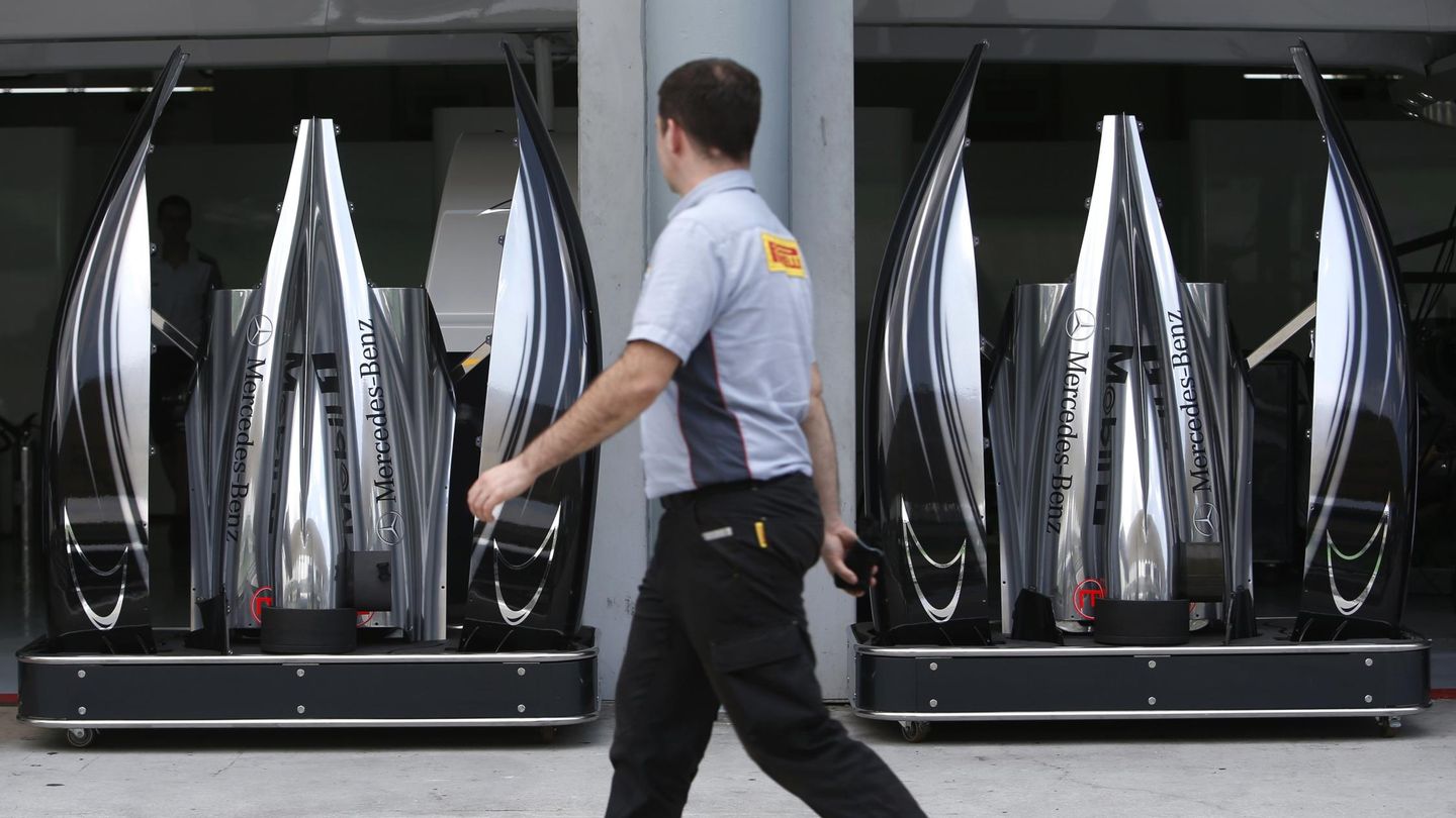Un trabajador de Pirelli observa una parte de los Mercedes.