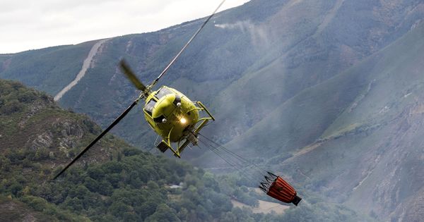 Foto: Un helicóptero descarga agua en un incendio forestal. (EFE)
